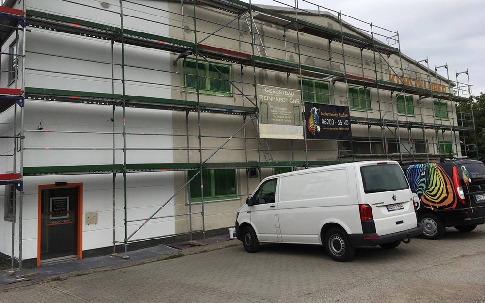 Eingerüstete Hausfassade mit Firmenfahrzeug von Malermeister Fischer